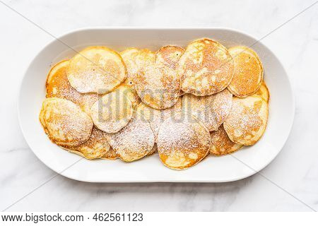 Freshly Made Small Pancakes On A Kefir Base Garnished With Powdered Sugar.