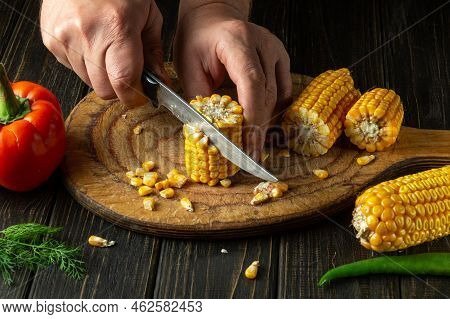 The Cook Cuts Corn Kernels With A Knife. Maize Is An Excellent Dietary Breakfast Or Lunch By The Che