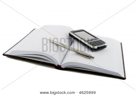 Close Up Noutbook, Pen And Mobile Phone On It Isolated Over White