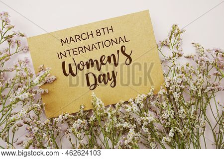 International Women's Day Written On Paper Card With Flower Frame Decoraton On Pink Background