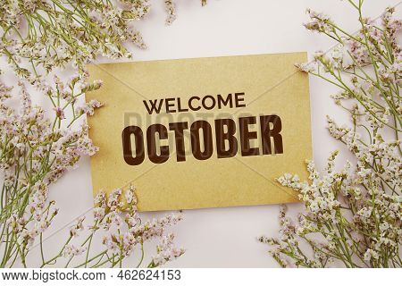 Welcome October Written On Paper Card With Flower Frame Decoraton On Pink Background