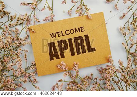 Welcome April Written On Paper Card With Flower Frame Decoraton On Pink Background