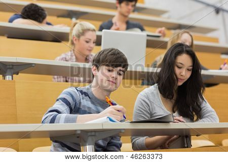 Studenti in ascolto e prendere appunti in una sala di conferenza in un college