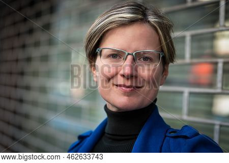 Tired Looking 30 Yo White Woman Posing Against A Metal Fence, Brussels