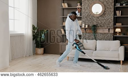Adult African American Homeowner Cleaner Washing Floor Parquet Surface With Vacuum Cleaner In Dwelli