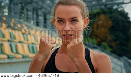 Motivated Female Fighter Athlete With Clenched Fists Standing In Boxing Stance Punching Air Dynamic 