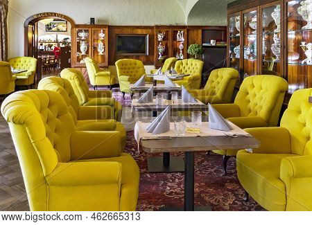 Estonia, Viljandi, September, 2022: Cozy Restaurant Interior With Upholstered Yellow Furniture And V
