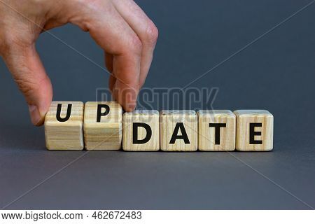 Date Or Update Symbol. Businessman Turns Wooden Cubes And Changes The Concept Word Date To Update. B