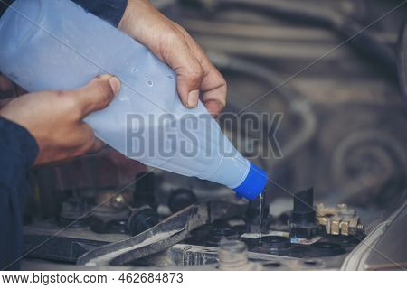 Car Mechanic Man Hands Pouring Deionized Purified Distilled Water For Car Battery Mechanical Service
