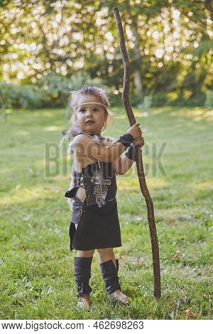 Cute Baby Dressed In The Clothes Of Primitive People With Combat Staff