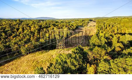 Transmission Tower Or Electricity Pylon Or Steel Lattice With Overhead Power Lines In A Path Cut Thr