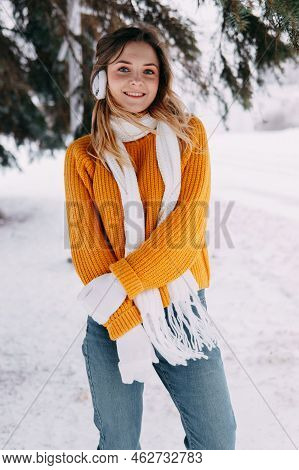 Teen Blonde In A Yellow Sweater Outside In Winter. A Teenage Girl On A Walk In Winter Clothes In A S