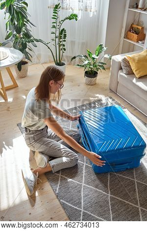 A Young Woman Is Packing Suitcase, She Is Forced To Leave Her House. Forced Relocation, Flight From 
