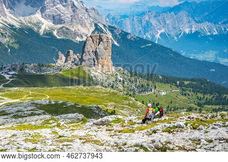 Two Hikers Sitting And Looking On Five Towers, Italian: Cinque Torri Di Averau, Impressive Rock Form