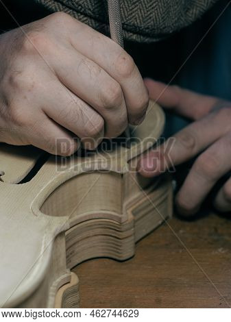 Close Up Of Professional Master Artisan Luthier Painstaking Detailed Work On Wood Violin In A Worksh