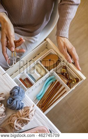 Female Hands Putting Scissors Into Drawer With Sewing Accessories Neatly Placing Organizing Top View