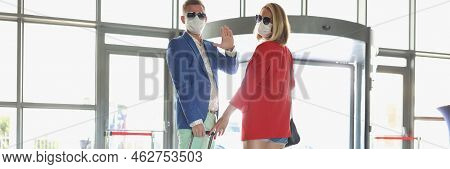 Portrait Of Couple Dressed In Luxury Suits With Suitcase Wave Goodbye Before Flying On Vacation. Man
