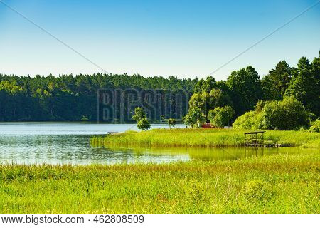 Lake In Masuria Lakeland In Poland. Water Shore Overgrown With Green Reeds. Summer Landscape In Euro