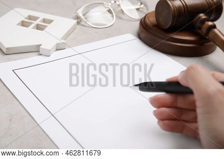 Woman Signing Last Will And Testament At Light Grey Table, Closeup