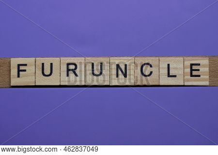 Word Furuncle Made From Wooden Gray Letters Lies On A Lilac Background