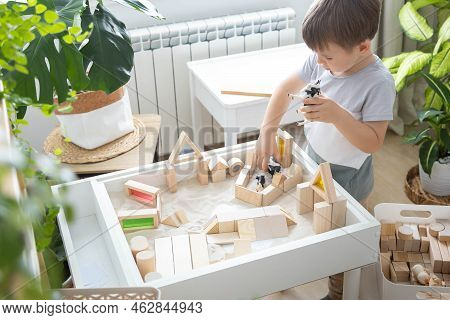 Cute Boy Kid Playing Sensory Box Kinetic Sand Table With Montessori Wooden Materials
