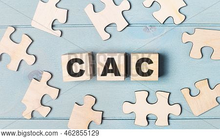 Blank Puzzles And Wooden Cubes With The Text Cac Customer Acquisition Cost Lie On A Light Blue Backg
