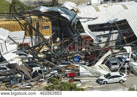 Hurricane Ian Destroyed Industrial Building With Damaged Cars Under Ruins In Florida. Natural Disast
