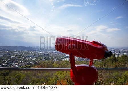 Red Stationary Binoculars On The Panorama Of The City