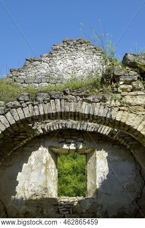 Ruins Of An Ancient Christian Temple Against Blue Sky. Collapsed Ceiling. Masonry, Room With Arched 