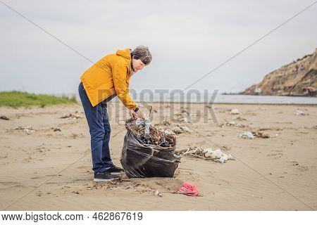 Plastic Garbage. Sea And Ocean Pollution. Beach Clean Up. Young Man Picking Used Plastic Bottles On 