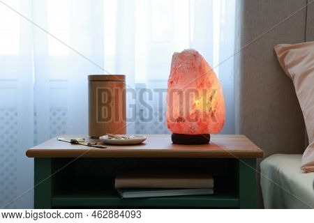Himalayan Salt Lamp, Air Ionizer And Accessories On Nightstand In Bedroom