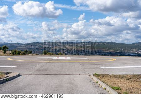 Helipad. Helicopter Landing Pad Near Emergency Hospital In Portugal With Cloud Sky And City On Backg