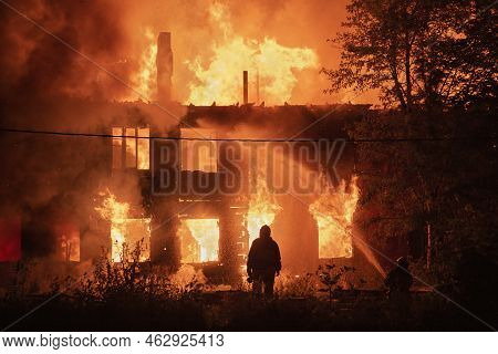 Two Silhouette Of Firefighters On Housefire Background