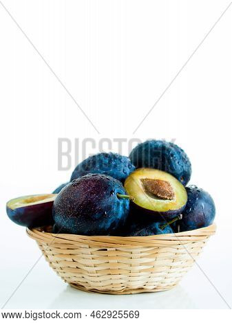 Fresh Plums In Basket On White Background.