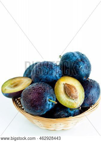 Fresh Plums In Basket On White Background.