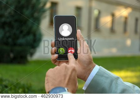 Man Declining Incoming Call From Unknown Caller Outdoors, Closeup. Be Careful - Fraud