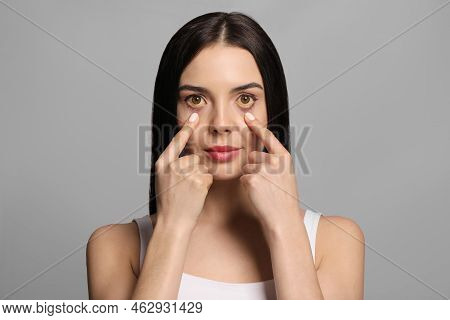 Woman Checking Her Health Condition On Grey Background. Yellow Eyes As Symptom Of Problems With Live