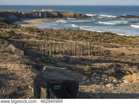 Stone With Blue And Green Sign Of Fishermans Trail And View Of Praia Grande De Almograve Sand Beach 
