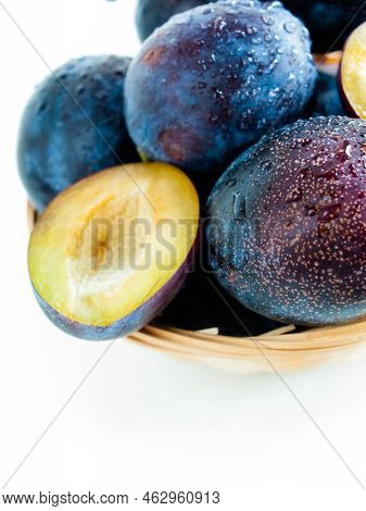 Fresh Plums In Basket On White Background.