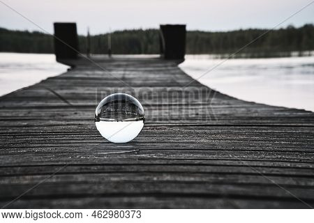 Glass Ball On A Wooden Walkway On A Swedish Lake At The Blue Hour. Nature Shot From Scandinavia