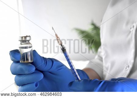 Nurse Holds A Syringe And Vaccine Bottle In His Hand Close Up. Doctor Ready To Give An Injection. Sc