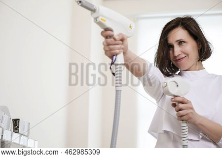 Professional Funny Female Doctor Posing In Doctor's Smock While Holding Two Intence Pulse Light Appa