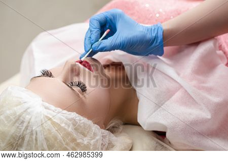 Closeup Of Young Caucasian Woman Lips During A Process Of Permanent Lips Makeup In Tattoo Salon.