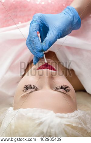 Closeup Of Young Caucasian Woman Lips During A Process Of Permanent Lips Makeup In Tattoo Salon.
