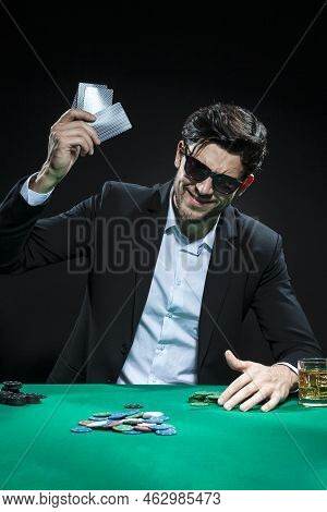 One Emotional Handsome Caucasian Brunet  Pocker Player At Pocker Table With Chips And Cards While Pl