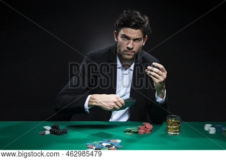 One Emotional Handsome Caucasian Brunet  Pocker Player At Pocker Table With Chips And Cards While Pl