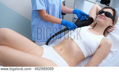 Young Woman Undergoes Armpit Laser Hair Removal Treatment At Beauty Spa. Hair Removal In Hone Armpit
