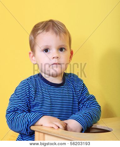 Cute caucasian toddler missing his mum in kindergarten.