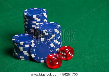 Blue Poker Chips And Red Cubes On The Green Table