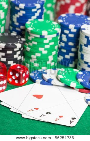 Dice, Four Aces And Colorful Chips On A Green Felt